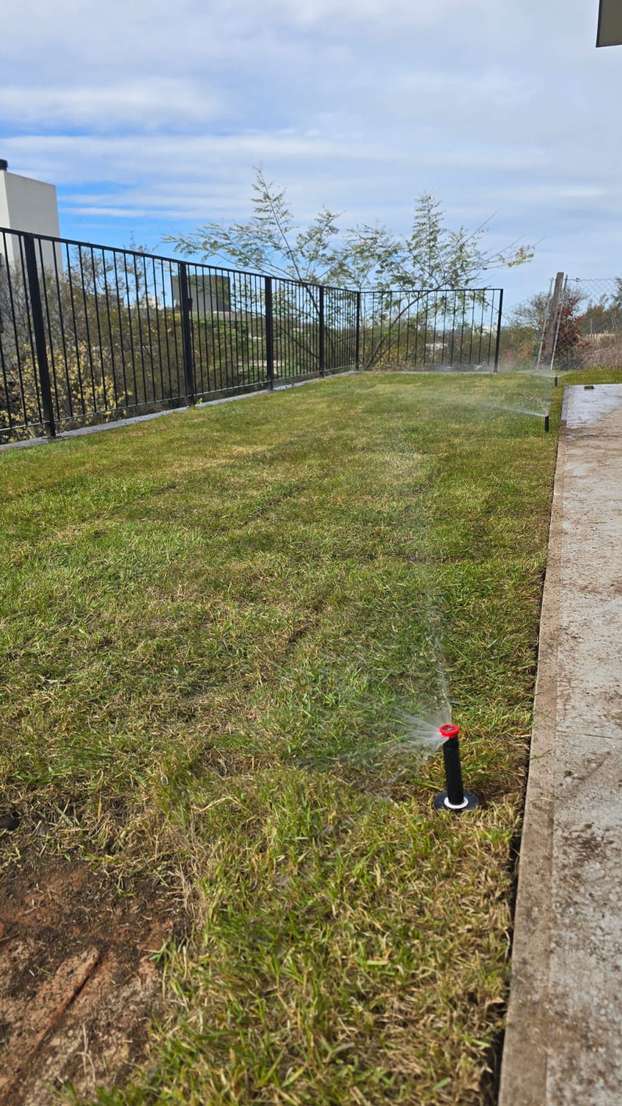 Aspersor automático funcionando en jardín con césped en La Calera Córdoba
